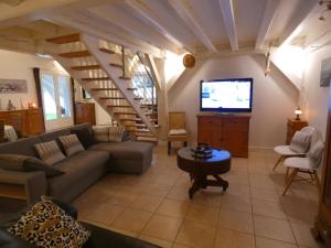 Una sala de estar con un sofá y un televisor. en Louisiane, en Onard