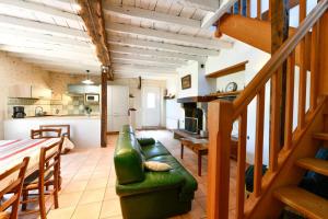 a living room with a green couch and a kitchen at Chez evon in Jurançon