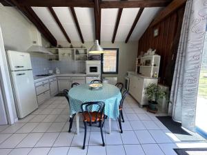 a kitchen with a table with chairs and a kitchen with white appliances at Peyrot in Onesse-et-Laharie