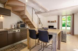 a kitchen with a wooden table and a staircase at Le gîte de l'eau claire in Polisy