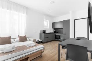 a white living room with a bed and a table at MI CASA - Appartamento in Ponte Nuovo in Milan