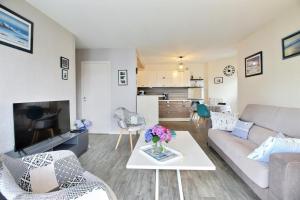 a living room with a couch and a table at A deux pas du port in Vannes