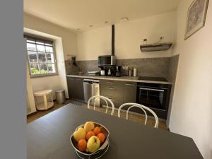 a kitchen with a bowl of fruit on a table at Gîte jean in Horsarrieu