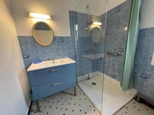 a bathroom with a blue sink and a shower at Le moulin in Préchacq