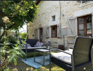 patio z krzesłami i stołem przed budynkiem w obiekcie Chez l'antoinette w mieście Persac
