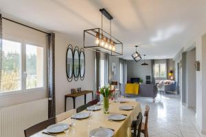 a dining room with a table and a living room at Les bigarreaux in Paisy-Cosdon