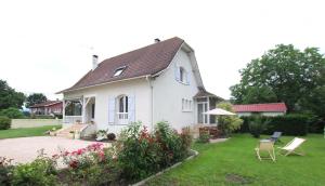 a white house with a yard with chairs and flowers at Lajus fontaine in Livron