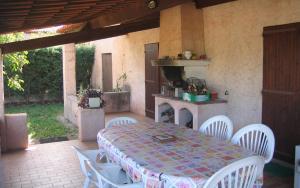 a patio with a table and chairs and a fireplace at Gite calme et agreable in La Motte