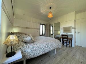 a bedroom with a bed and a desk and a table at Cyralie in Asson +32 photos