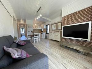 a living room with a couch and a brick wall at Cyralie in Asson