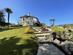 a house with a stone path in front of a yard at Cyralie in Asson