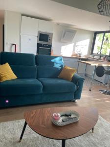 ein blaues Sofa im Wohnzimmer mit einem Tisch in der Unterkunft Charmant appartement à Bordeaux in Bordeaux + 12 Fotos