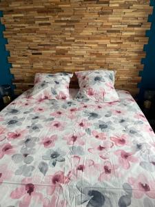ein Schlafzimmer mit einem Bett mit rosa Blumen darauf in der Unterkunft Charmant appartement à Bordeaux in Bordeaux