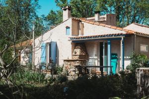 a small white house with a table in front of it at Gite au calme l'eclaircie in Régusse