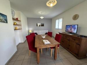 a dining room with a wooden table and red chairs at Gabardan in Mugron