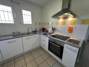 a kitchen with white cabinets and a stove top oven at Gabardan in Mugron