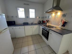 a kitchen with white cabinets and a stove top oven at Marensin in Mugron