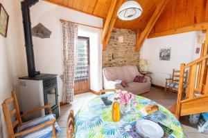 a living room with a table and a fireplace at Gîte Gîtes de France 2/3 personnes à Malecombe in Cubières
