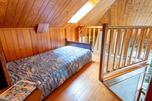 a bedroom with a bed in a room with wooden walls at Gîte Gîtes de France 2/3 personnes à Malecombe in Cubières