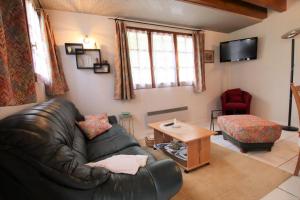 a living room with a leather couch and a table at Cauhape in Auga