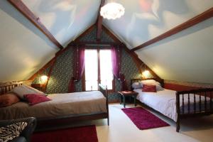 a attic bedroom with two beds and a window at Cauhape in Auga +30 photos