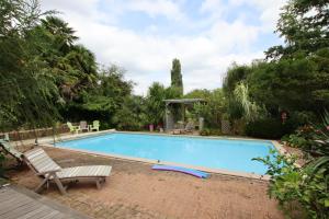 a swimming pool with a bench and a chair next to it at Cauhape in Auga