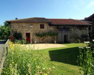 a stone house with a yard in front of it at Les moissonneurs in Champagnac-la-Rivière