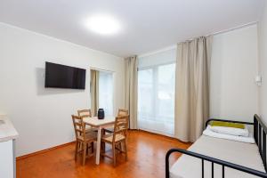 a room with a bed and a table and chairs at Smilciu 34 in Palanga