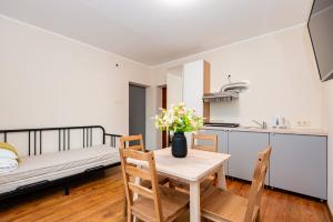a kitchen and dining room with a table with flowers on it at Smilciu 34 in Palanga