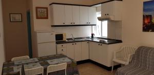 Una pequeña cocina con una mesa y un microondas. en Viviendas XXIII, en Puerto del Rosario