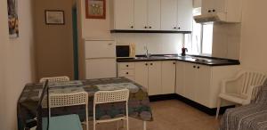 cocina con mesa y sillas y cocina con fregadero en Viviendas XXIII, en Puerto del Rosario