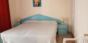 Una cama con cabecera azul y dos mesitas de noche azules. en Viviendas XXIII, en Puerto del Rosario 47 fotos más