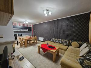 a living room with a couch and a table at Частен Апартамент Пампорово Гранд Манастира 2Б5 in Pamporovo