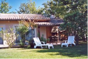 two white chairs and a table in front of a house at Rose in Biscarrosse