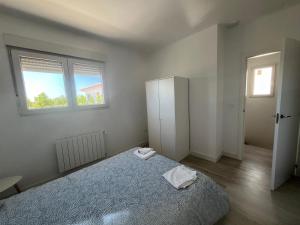 Un dormitorio blanco con una cama y dos ventanas. en Eco Home Alpera 1, en Alpera