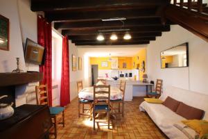 een woonkamer met een tafel en een keuken bij La foret in Aydie