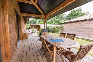 a wooden deck with a wooden table and chairs at callune in Biscarrosse