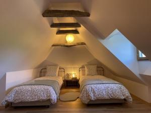 two beds in a room with a attic at Le gout in Lasseubetat