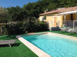 a swimming pool in a yard next to a house at Le gîte le belvedère in Bauduen