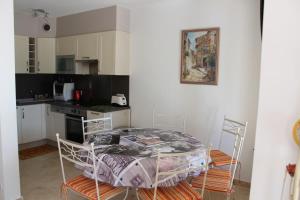 une cuisine avec une table et des chaises dans une pièce dans l'établissement Joli gite les palmiers iii, à La Croix-Valmer