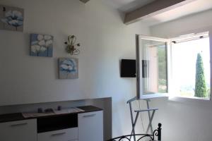 une cuisine avec un bureau, une chaise et une fenêtre dans l'établissement Joli gite les palmiers iii, à La Croix-Valmer