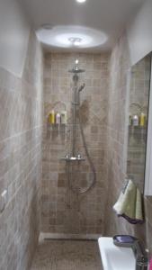 La salle de bains carrelée est pourvue d'une douche et d'un lavabo. dans l'établissement Joli gite les palmiers iii, à La Croix-Valmer