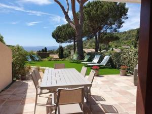 une table blanche et des chaises sur une terrasse dans l'établissement Joli gite les palmiers iii, à La Croix-Valmer