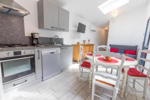 a kitchen and dining room with a table and chairs at La maison de mon grand-père, appt la landaise du lac in Léon +19 photos