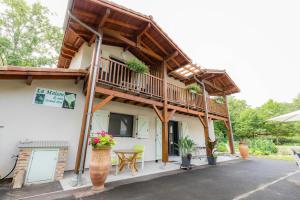 a house with a balcony and a table and chairs at La maison de mon grand-père, appt la landaise du lac in Léon