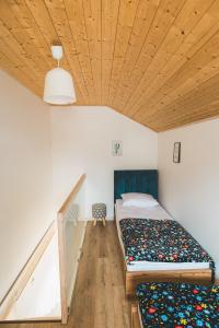 a bedroom with two beds and a wooden ceiling at Domki Borys in Jastrzębia Góra +291 photos