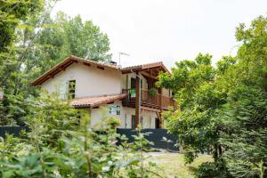 a house seen through the trees at La maison de grand-pere, appt cote lac in Léon