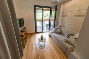 a living room with a couch and a television at La maison de grand-pere, appt cote lac in Léon