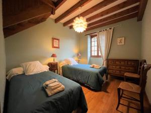 a bedroom with two beds and a chandelier at Aguerre in Lichos