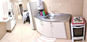 a kitchen with a sink and a refrigerator at Casa Stylo Garanhuns Temporada in Garanhuns